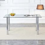 A modern minimalist style glass dining table with glass table top and silver metal legs